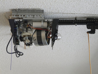 Close-up of an automatic garage door opener motor gear drive needing repair at a residence. 