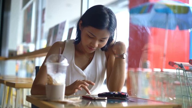 Girl laughs while typing text on smart phone in coffee shop 4k UHD (3840x2160)
