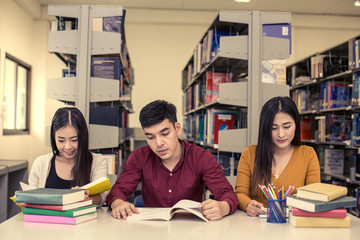 Group of Student reading books in the library with attractive smiling together . People with Education concept. vintage color tone.