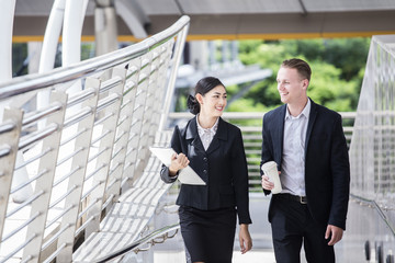 Happy Asian Businesswoman walking and talk about Work with Businessman. People Work at outdoor place. Woman Working Concept.