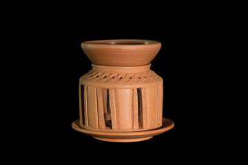 Isolated terracotta stove for aromatherapy on black background