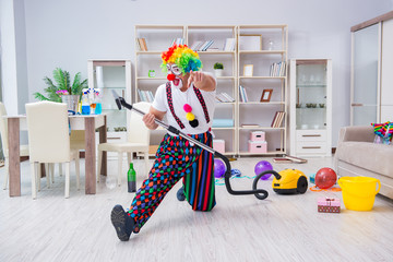 Funny clown doing cleaning at home