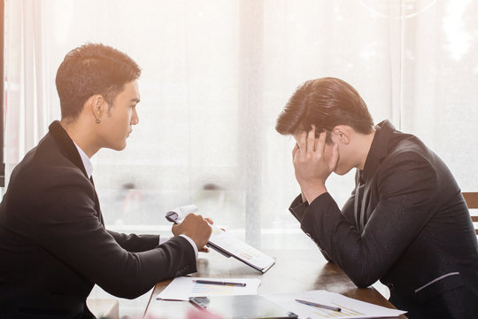 Two men  Asian business meeting man sitting stress with work on the table and sunset background. - Powered by Adobe