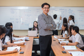 Portrait of Asian teacher standing when Giving Lesson to group of College Students in the...