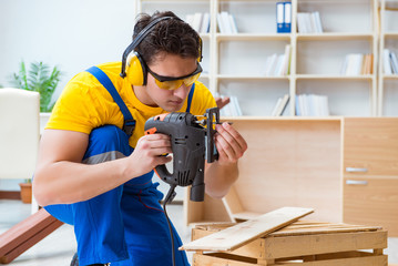 Repairman carpenter cutting sawing a wooden board with an electr