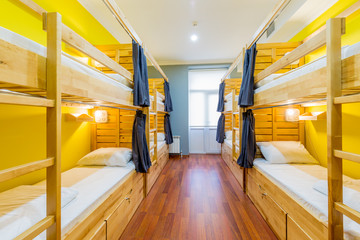 Hostel dormitory beds arranged in room - obrazy, fototapety, plakaty