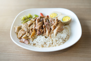 Stewed pork leg with rice on wooden table, Street food in Thailand