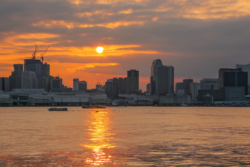 Obraz premium Cloudy sky over skyscrapers at sunset, Odaiba, Tokyo, Japan. 