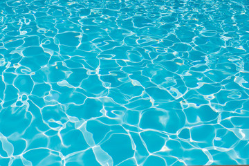 Blue and bright water surface and ripple wave with sun reflection in swimming pool