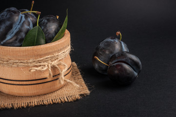 Garden plums in bowl on stone table. View with copy space