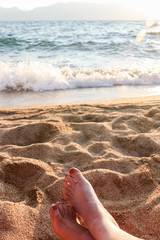 Fototapeta na wymiar Closeup of Womans Legs and Feet at the Beach