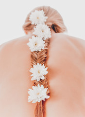 beautiful young girl with long hair with flowers in braid