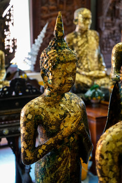 Old standing buddha image statue with Friday posture covered by gold leaf, Asokaram temple