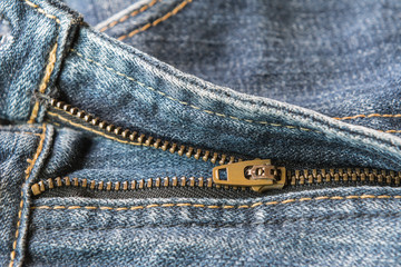 brass zipper of old fade denim jeans, clothing and fashion concept © Arnut