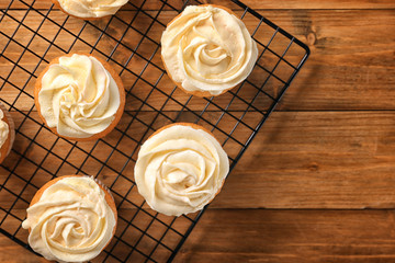 Cooling rack with delicious carrot muffins on wooden table