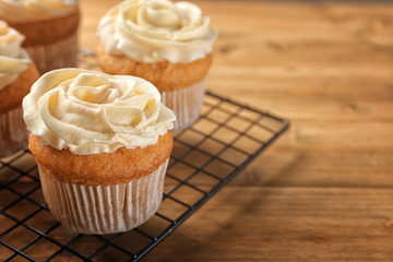 Cooling rack with delicious carrot muffins on wooden table