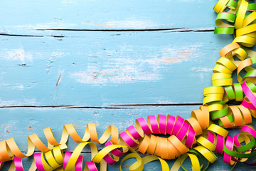 Bunte Luftschlangen mit Textfreiraum, Holz in Blau, Konzept Karneval und Feier
