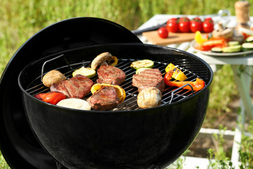 Cooking tasty meat and vegetables on barbecue grill outdoors