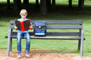 Fototapeta premium Kid doing homework outdoors after school