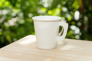 a white paper coffee cup in the morning time