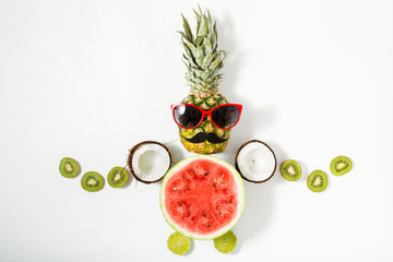 Creative layout made of funny pineapple with sunglasses and fruits