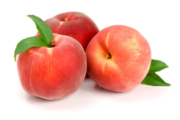 Three peaches with green leaf isolated on white background