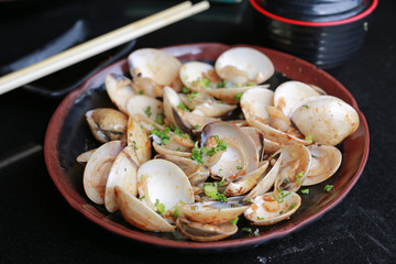 Fried Clams with spicy in plate on black table.