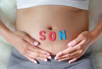 Pregnant woman with SON word in front of her belly.