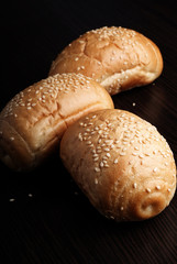 Wheat roll with sesame seeds on dark background