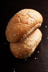 Wheat roll with sesame seeds on dark background