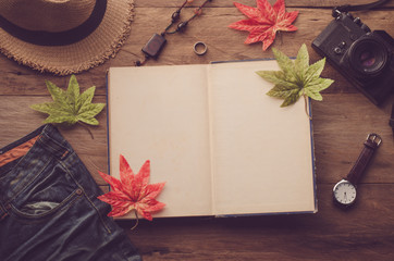 Maple leaf on wooden background at summer and notebook for your text