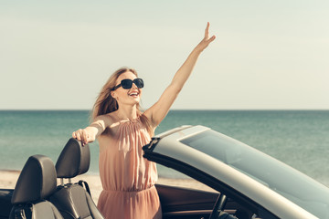Obraz na płótnie Canvas Young woman drive a car on the beach