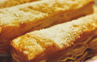 Puff pastry cakes with sugar powder close up