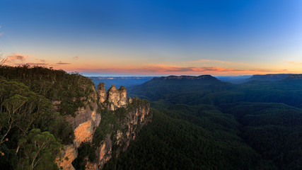 Fototapeta na wymiar Beautiful View Panorama of the famous Three Sisters rock formation in the Blue Mountains National Park at twilight close to Sydney, Australia