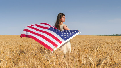 Beautiful girl with a US flag in the field