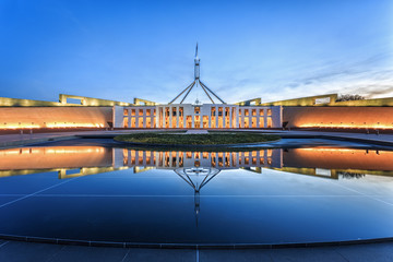 Dramatic evening sky over Parliament House, illuminated at twilight. Which was the world's most expensive building when it was completed in 1988 in Canberra, Australia - obrazy, fototapety, plakaty