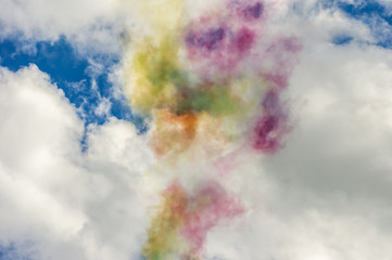 Colorful smoke in blue sky with clouds