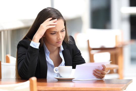Worried executive reading letter in a coffee shop