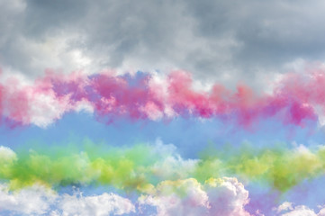 Colorful smoke in blue sky with clouds