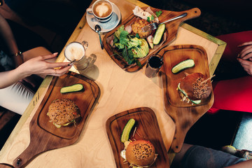 Food photography. Top view of hamburgers served with fresh vegetables, cucumbers on wooden boards in rustic style