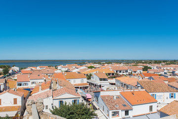 Fototapeta na wymiar Saintes-Maries-de-la-Mer in Camargue, panorama of the town, tiles roofs, and the swamps, view from the church 