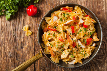 Pasta farfalle with chicken and paprika, in carbonara sauce.