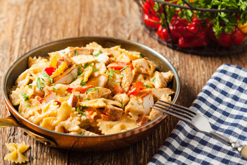 Pasta farfalle with chicken and paprika, in carbonara sauce.