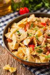 Pasta farfalle with chicken and paprika, in carbonara sauce.