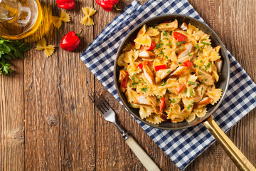 Pasta farfalle with chicken and paprika, in carbonara sauce.