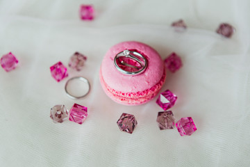 Wedding rings on the pink macaron with pink gems - Powered by Adobe
