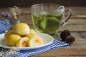 Chinese pastry with sweet mung bean and salted egg. Moon cake or Chinese pastry filled with mung bean paste and salted egg served with green tea. Delicious homemade Chinese pastry ready to served.