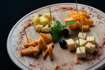pieces of cheese laid out on a wooden Board
