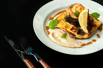 roasted trout on a pillow of bread with sauce and vegetables
