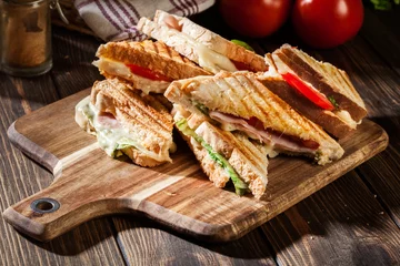 Zelfklevend Fotobehang Stapel panini met broodje ham, kaas en sla © Sławomir Fajer